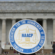 A logo is seen for the National Association for the Advancement of Colored People as NAACP President and CEO Cornell William Brooks speaks during a press conference at the Lincoln Memorial on June 15, 2015, in Washington, DC. Brooks announced “America’s Journey for Justice,” an 860-mile march from Selma, Alabama, to Washington, D.C., and a campaign “to protect the right of every American to a fair criminal justice system.